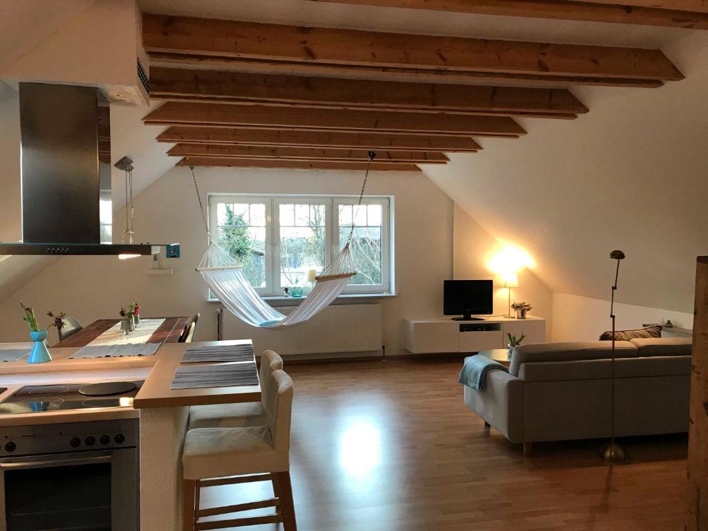 eine Küche und ein Wohnzimmer mit Holzdecken und einem Sofa in der Unterkunft Ferienwohnung Seegaard in Husby