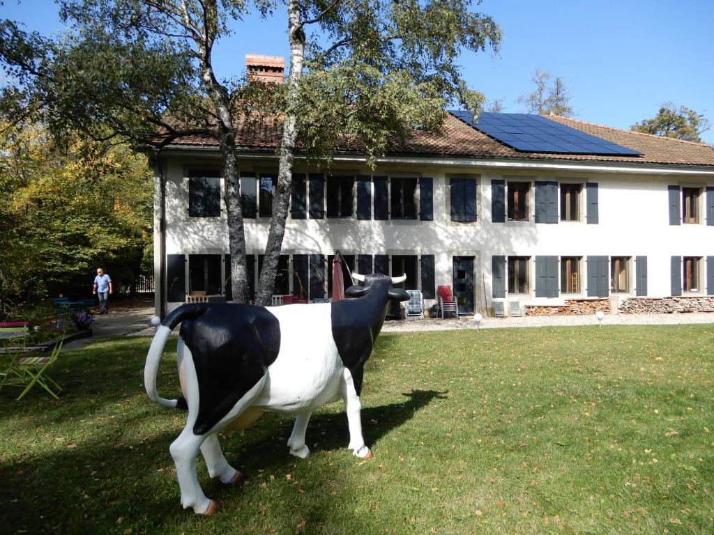 a statue of a cow in front of a house at Chambres d'hôtes T'22 in Fleurier