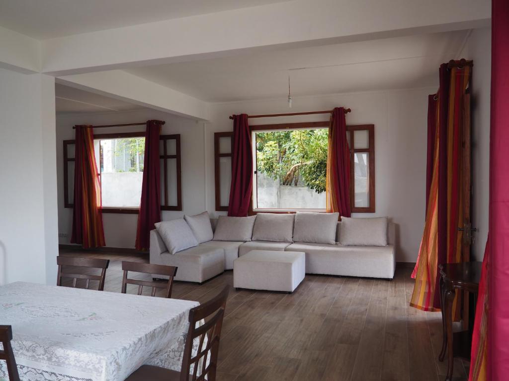 a living room with a white couch and a window at Maison familiale à Ile Maurice in Mahébourg