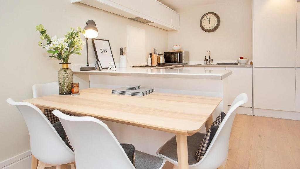 - une cuisine avec une table en bois et des chaises blanches dans l'établissement Compton Lodge Luxury apartment-Free Parking, à York