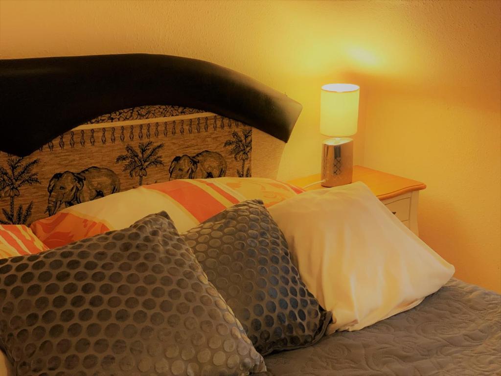 una camera da letto con letto, cuscini e lampada di Pálma Panzió a Kaposvár