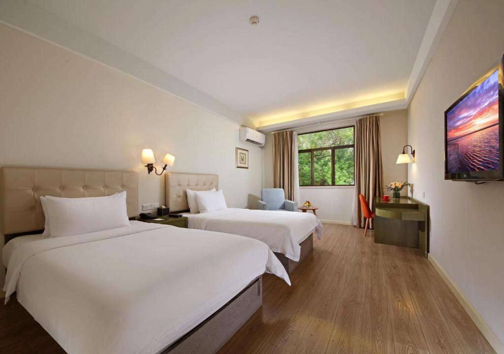 Postel nebo postele na pokoji v ubytování City Hotel Xiamen-Free Welcome Fruits