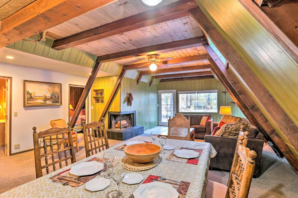 a dining room and living room with a table and a couch at Quaint and Rustic A-Frame Less Than 5 Mi to Plumas-Eureka! in Plumas Eureka