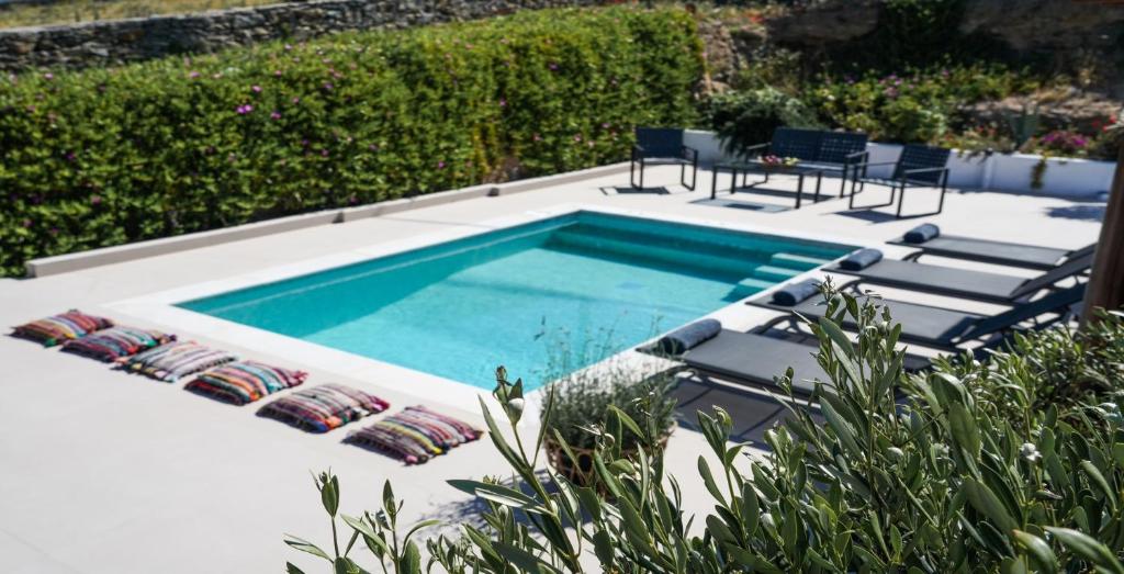 a swimming pool in a backyard with chairs and a table at Ortus Ivory Mykonian Lux Villa With POOL! in Mýkonos City
