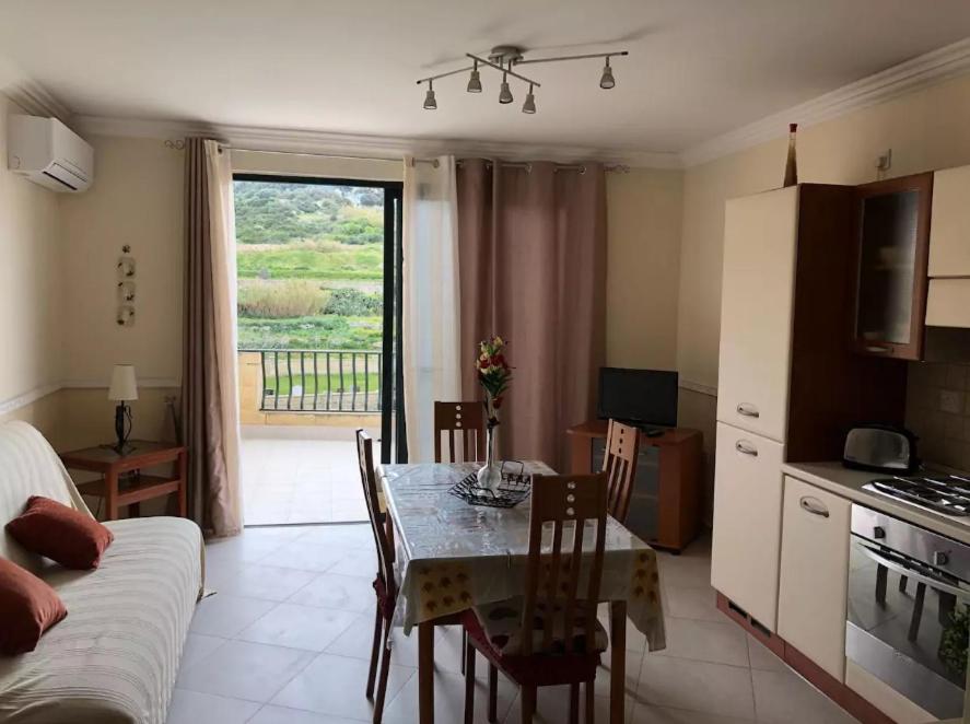 ein Wohnzimmer mit einem Esstisch und einer Küche in der Unterkunft Mellieha Seaside Apartment in Mellieħa