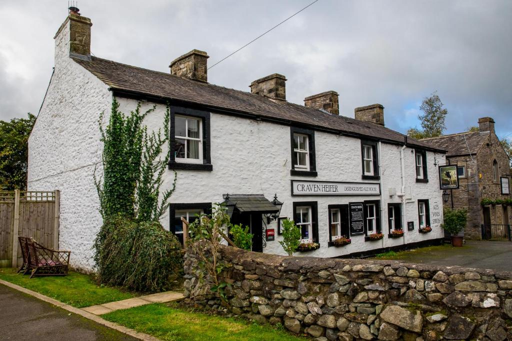 a white inn with a stone wall in front of it at Craven Heifer Ingleton in Ingleton 
