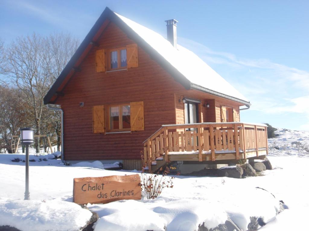 a log cabin in the snow with a sign in front at Chalet des Clarines in Saint-Genès-Champespe