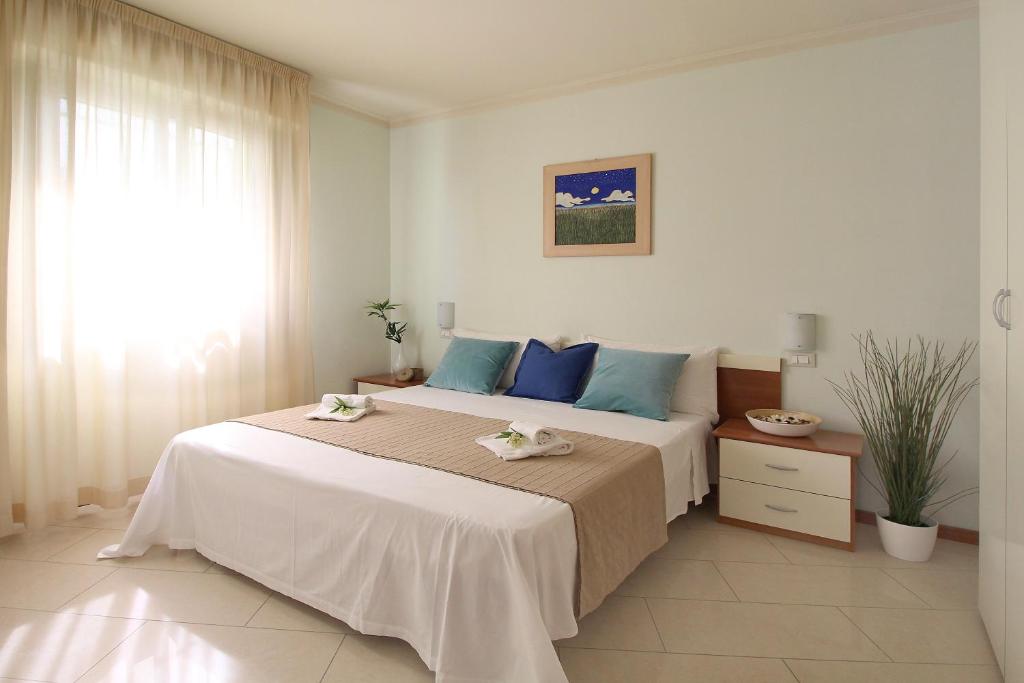 ein Schlafzimmer mit einem großen Bett mit blauen Kissen in der Unterkunft Residence Altamarea in San Mauro a Mare