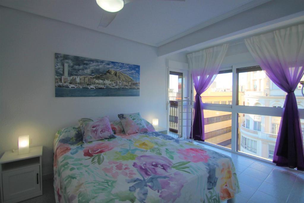 um quarto com uma cama e uma grande janela em CasaTuris Rambla Méndez Núñez en el corazón de Alicante A109 em Alicante