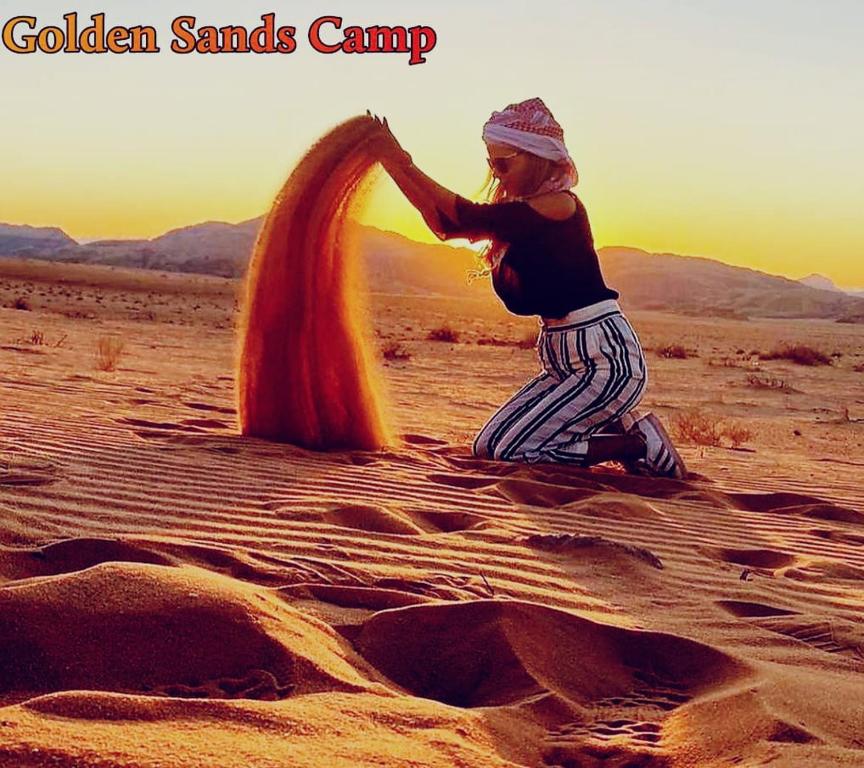 a woman is playing in the sand in the desert at Golden Sands Camp in Wadi Rum