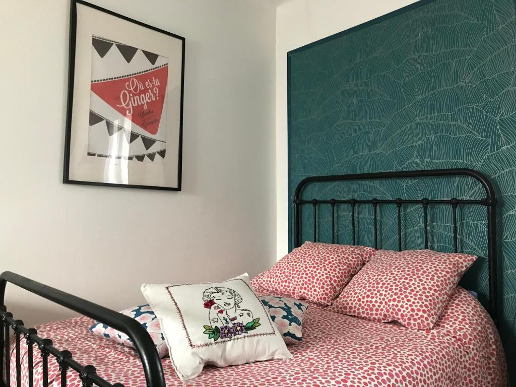 a bedroom with a bed with a green headboard at Gite Chez Ginger in Pézenas