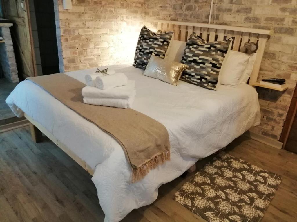 a large bed with pillows and towels on it at Pillow Place Parys in Parys