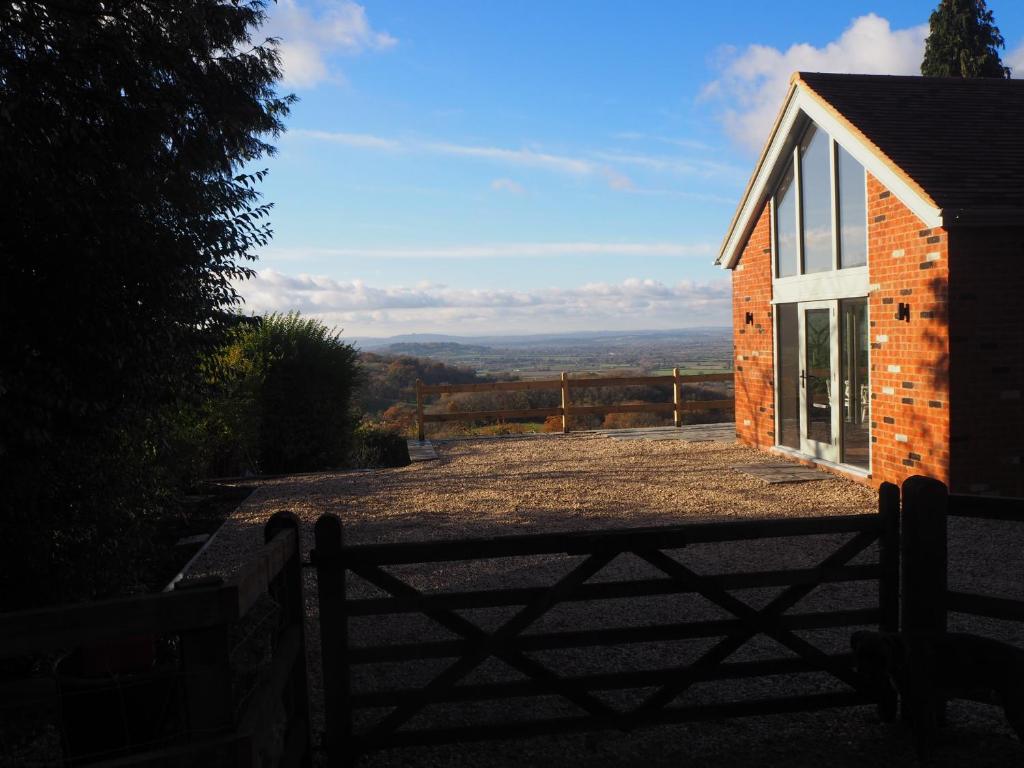 a brick building with a gate next to a house at Cheltenham View Lodge in Cheltenham