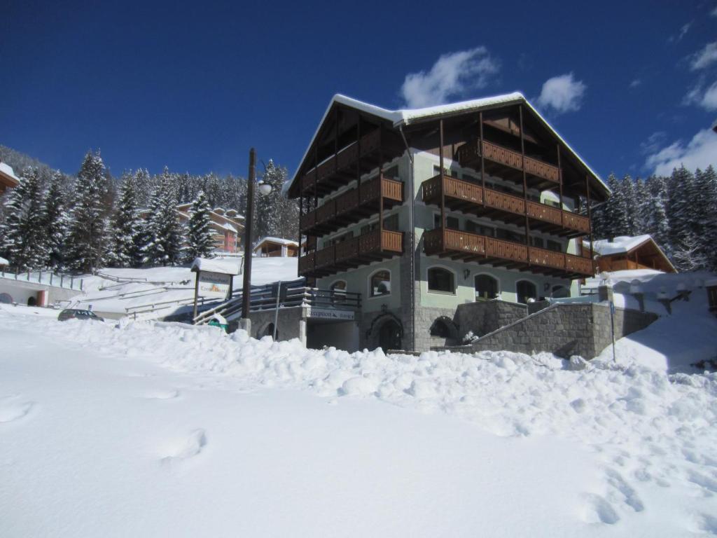a building covered in snow in front of it at RTA Torre Del Brenta in Madonna di Campiglio
