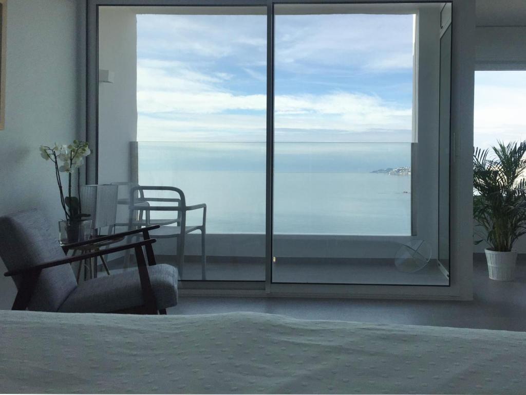 a bedroom with a view of the ocean from a window at Balcón del Albayzín in Salobreña