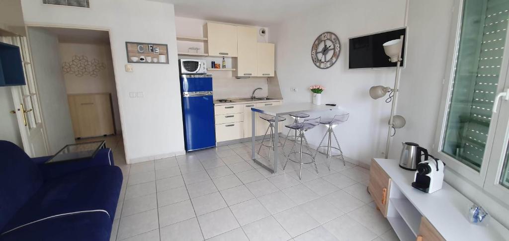 Il comprend une cuisine équipée d'un réfrigérateur bleu et d'une table. dans l'établissement Alery apartment Nice terrace AC wifi by Affitto-Nizza, à Nice