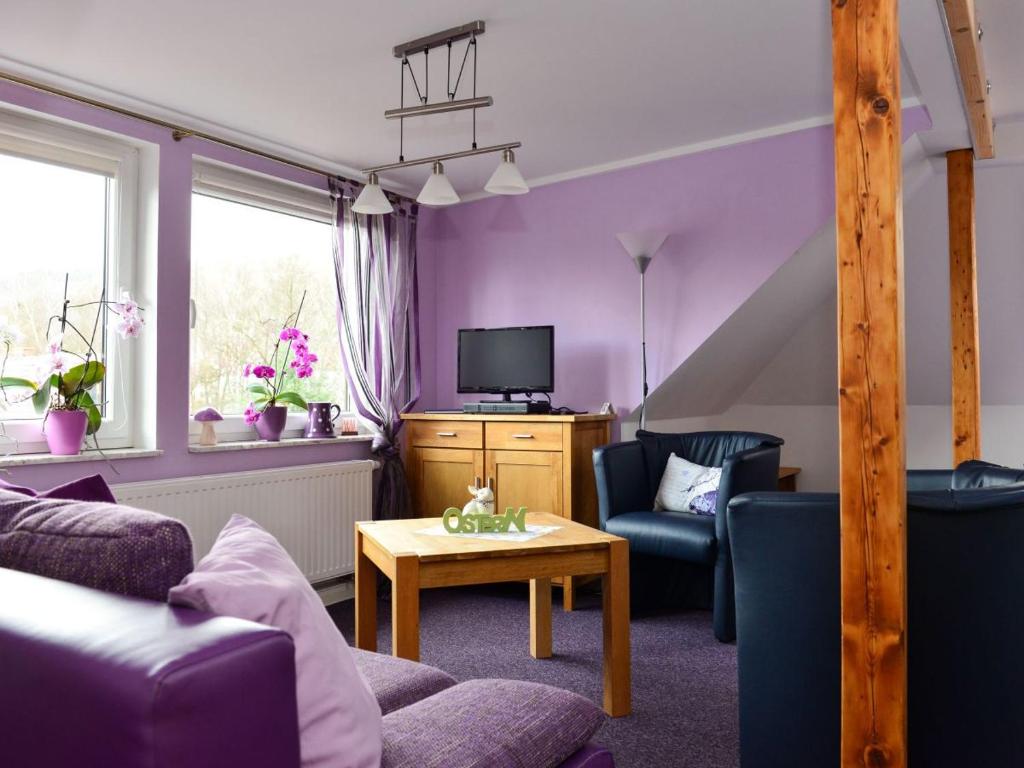 salon z fioletowymi ścianami i fioletowymi meblami w obiekcie Apartment Schneestern w mieście Suhl