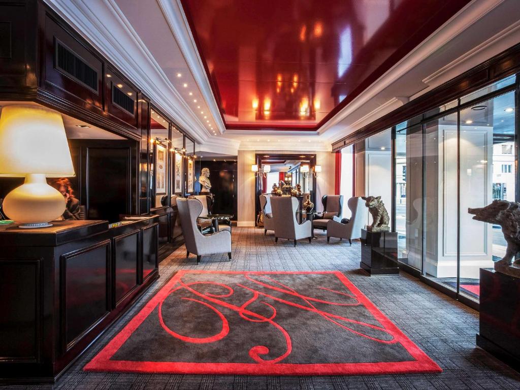 a hotel lobby with a red carpet on the floor at Park Hôtel Grenoble - MGallery in Grenoble