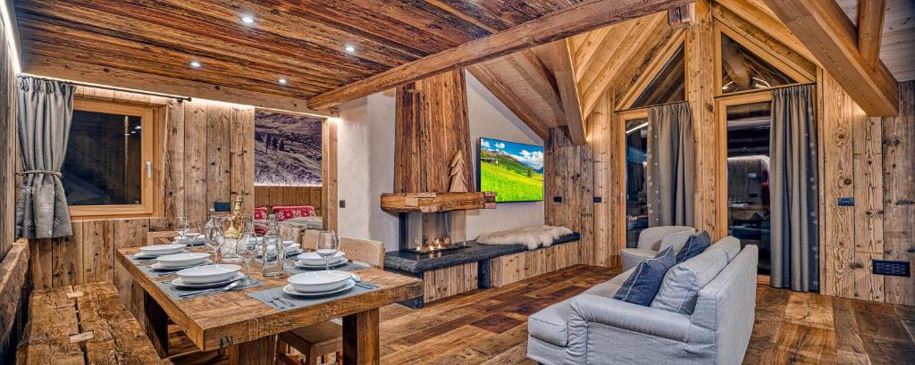 a dining room with a table and a tv in a cabin at Le Chalet Luxury Apartment in Livigno