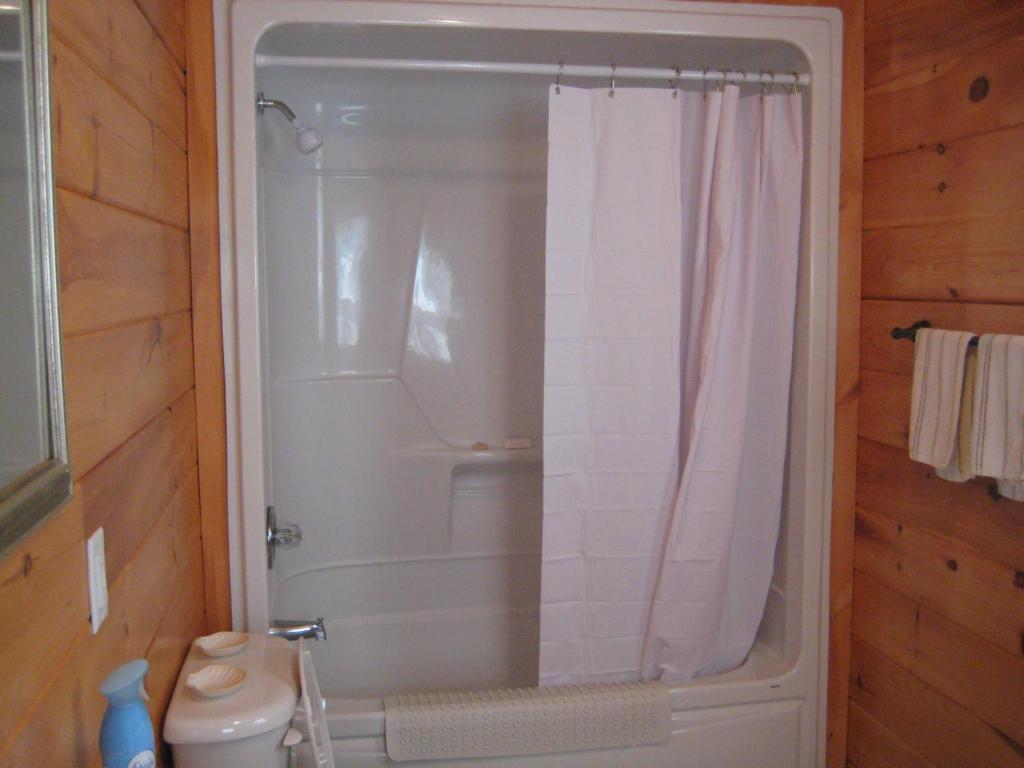 a bathroom with a shower with a white shower curtain at Princehaven Campground in Princeton