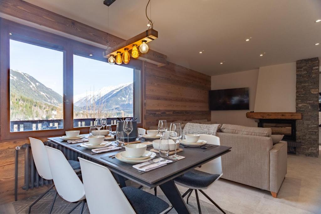 une salle à manger avec une table, des chaises et un canapé dans l'établissement Apartment Brevent Fodera, à Chamonix-Mont-Blanc