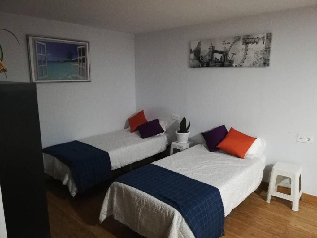1 dormitorio con 2 camas y una foto en la pared en Loft Santa Cruz, Acoran, en Santa Cruz de Tenerife