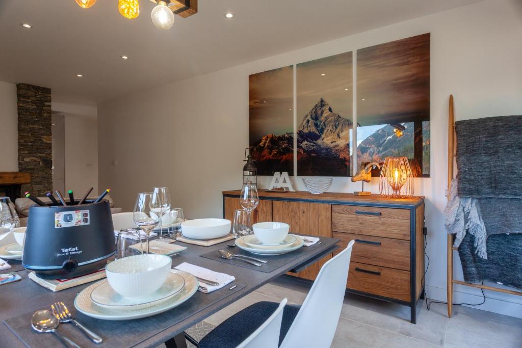 a dining room with a table with white dishes on it at Apartment Brevent Fodera in Chamonix