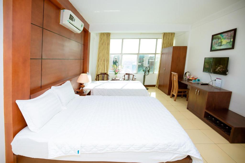 Postel nebo postele na pokoji v ubytování Viet Huong Hotel