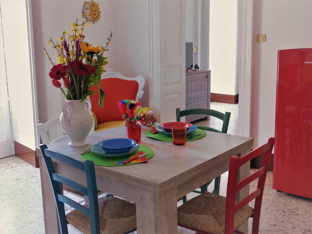 una mesa de comedor con un jarrón de flores. en Casa di Peppe, en Catania