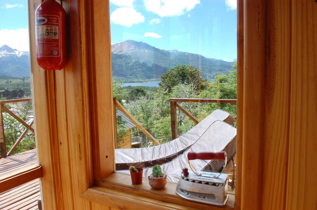 a view of a hammock from a window in a room at Parajes del lejano sur Cabaña El Patacón in Moquehue