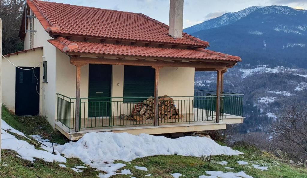 Cette maison dispose d'un balcon avec une pile de bois. dans l'établissement Ορεινή μονοκατοικία στα Χαλκιάνικα - Κοντά στη Ζαρούχλα - λίμνη Τσιβλού, à Khalkiánika