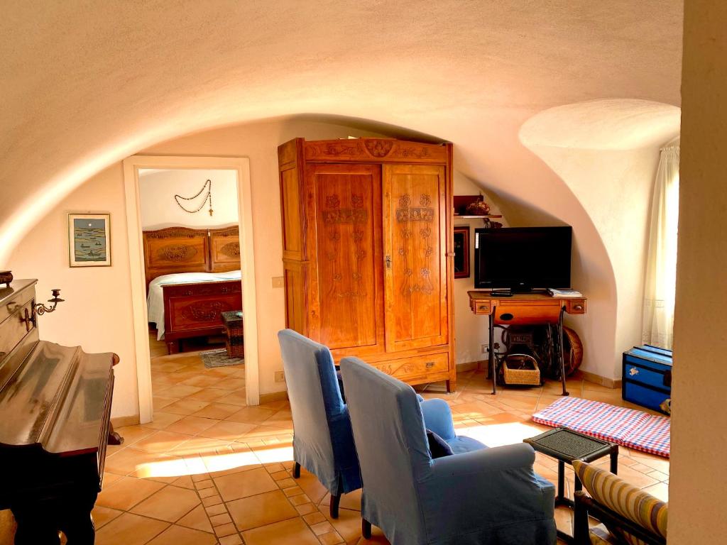 a living room with a tv and a couch and chairs at Casa del 1400 nell'antico Borgo di Cervo in Cervo