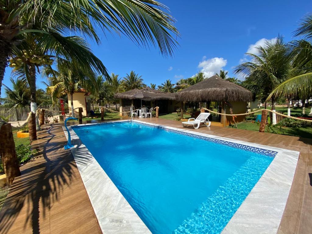 a swimming pool in front of a resort at POUSADA PONTA DA ASA in Coruripe