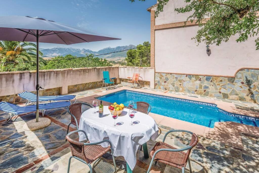 a table with an umbrella next to a swimming pool at El Manantial in Montecorto