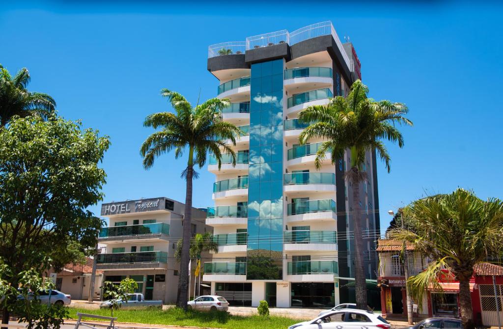 a tall building with palm trees in front of it at Hotel Eldorado in Paracatu