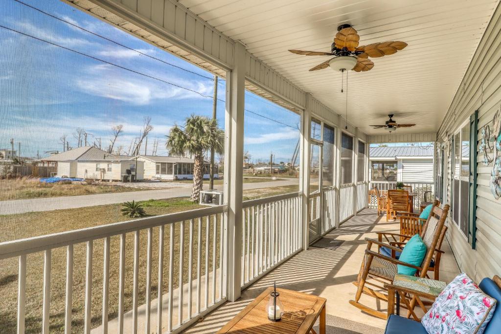 a porch with rocking chairs and a ceiling fan at Mermaid Manor in Mexico Beach