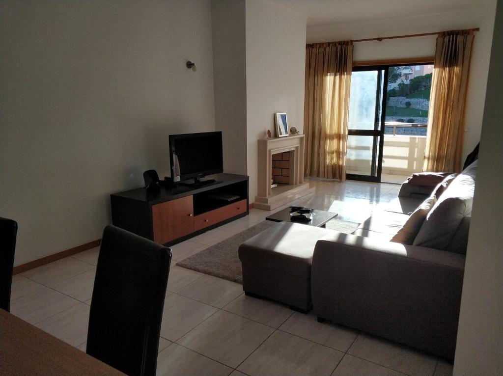 a living room with a couch and a tv at Cidade da Praia in Figueira da Foz