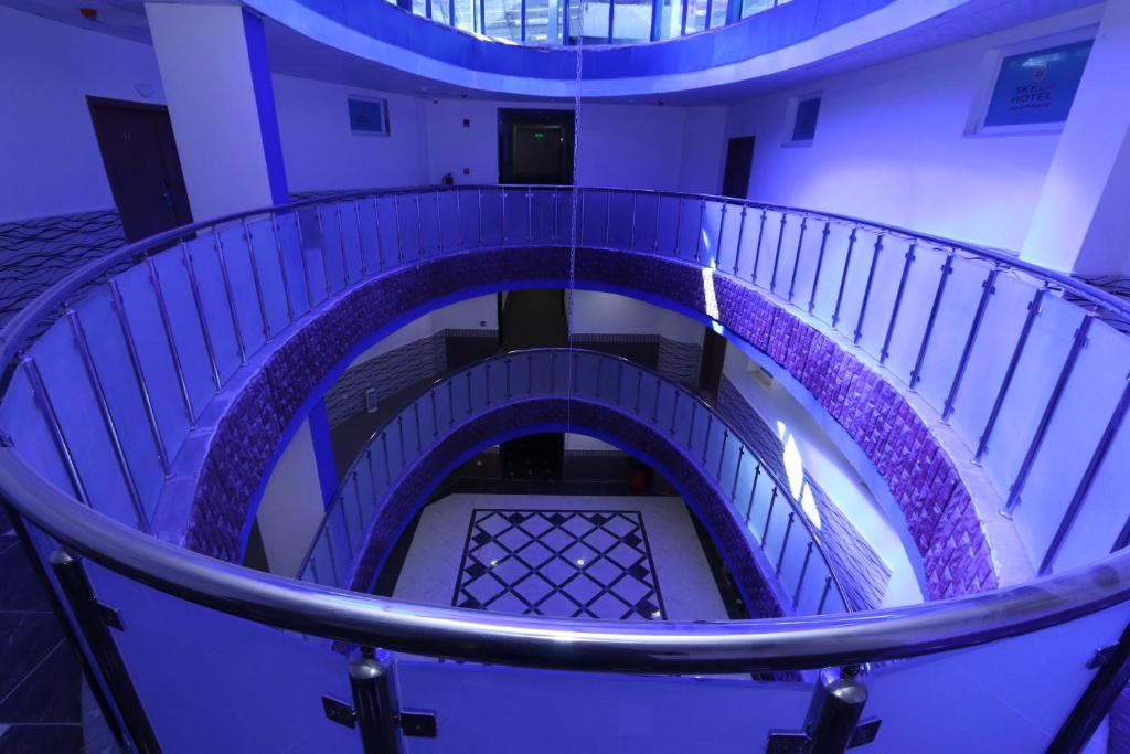 un escalier en colimaçon dans un bâtiment avec rampe violette dans l'établissement Skylight apartments, à Amman