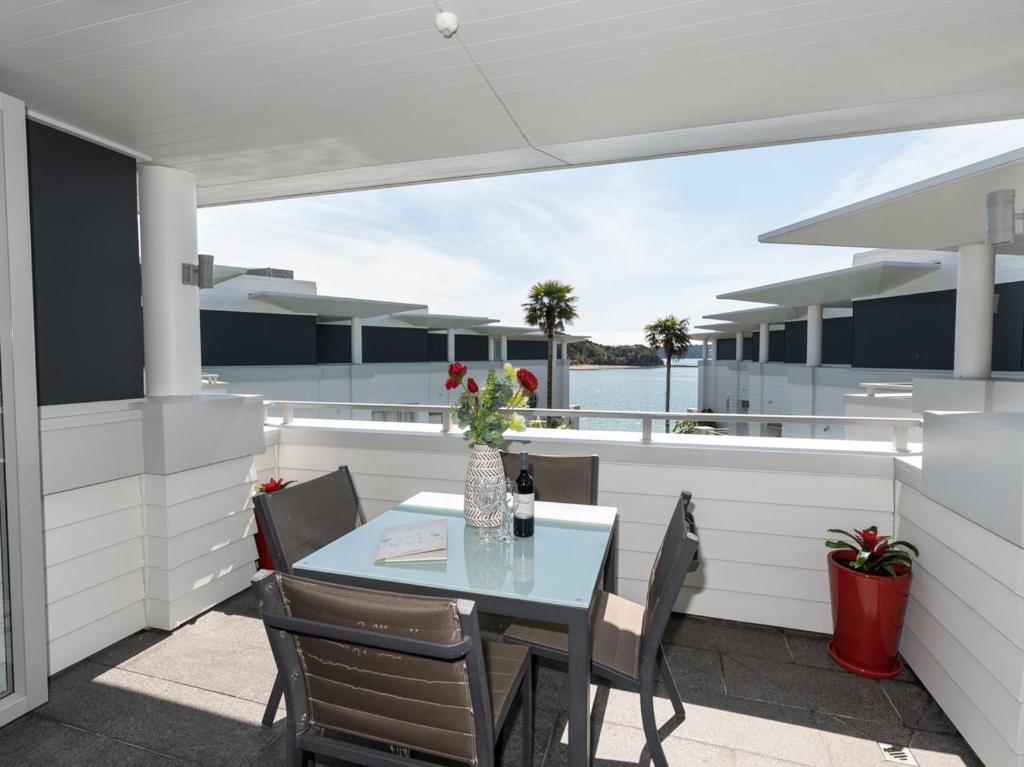 a balcony with a table and chairs on a yacht at High Tides Lookout - Paihia Holiday Home in Paihia