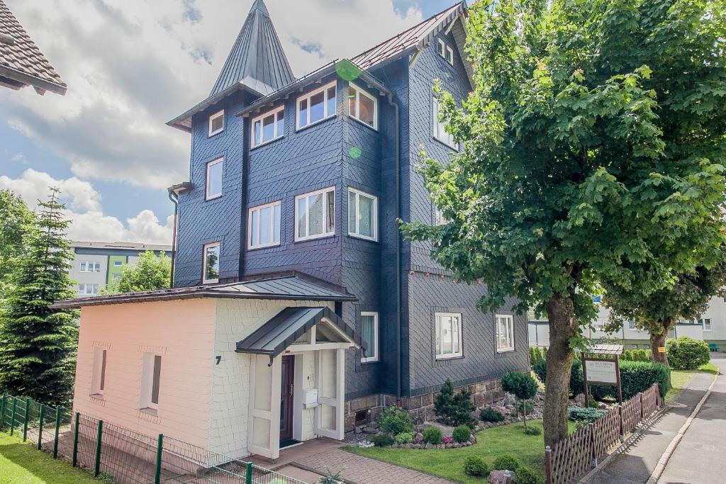 ein großes blaues Haus mit einem Baum davor in der Unterkunft Haus Repin in Oberhof