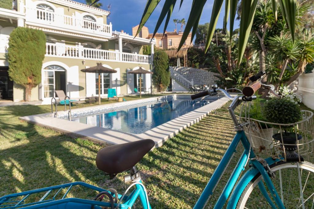 een blauwe fiets geparkeerd naast een zwembad bij Villa María in Málaga