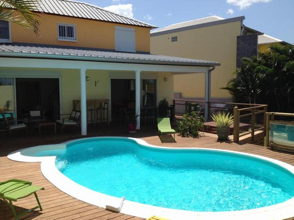 - une piscine en face d'une maison dans l'établissement La case à Nath - Piscine chauffée et jacuzzi, à Saint-Pierre