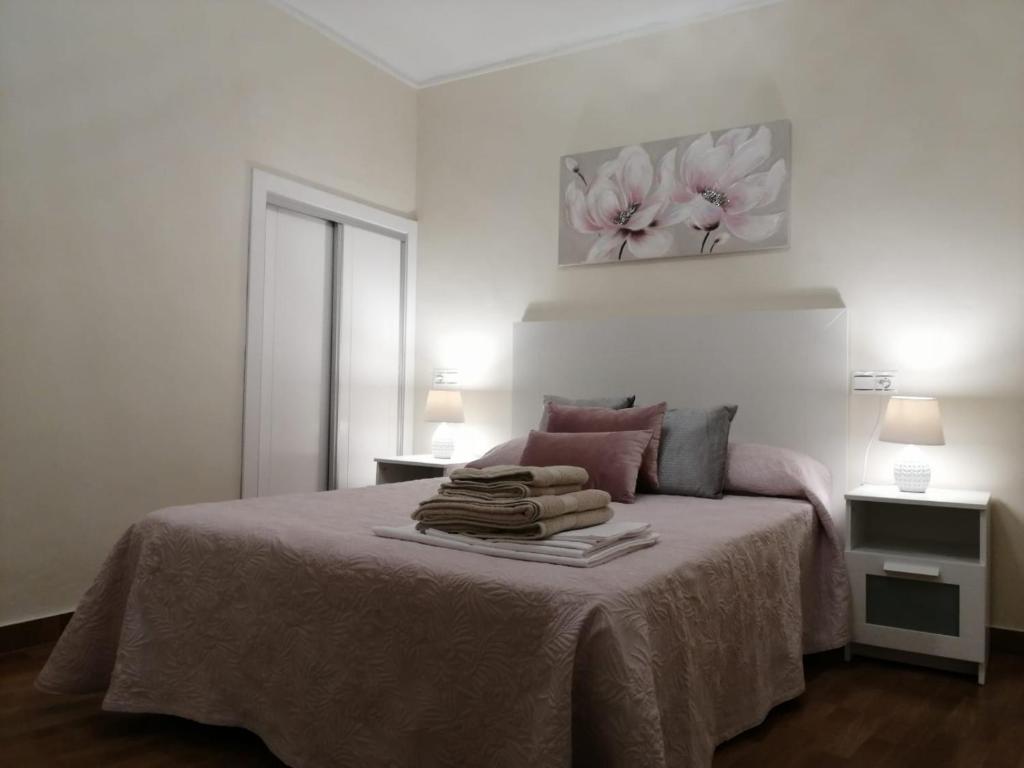 biała sypialnia z łóżkiem i ręcznikami w obiekcie Apartamento EntreCaminos w mieście Setenil