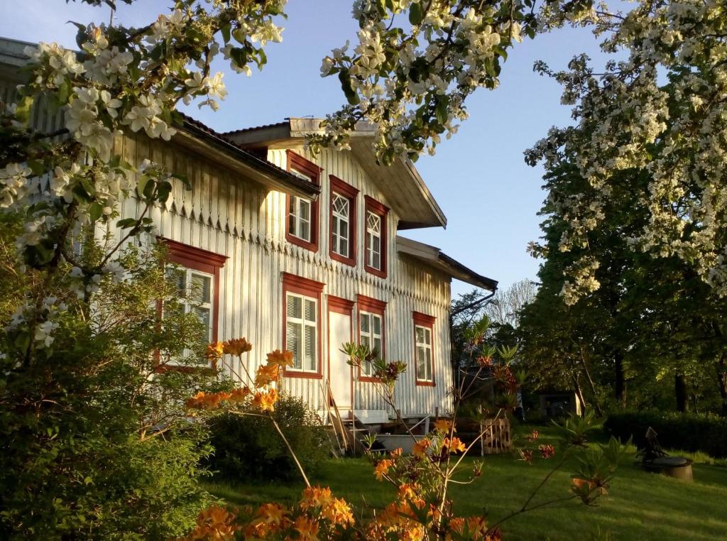 une maison avec des ornements rouges et blancs et des arbres dans l'établissement Esperöd Farm, à Lilla Edet