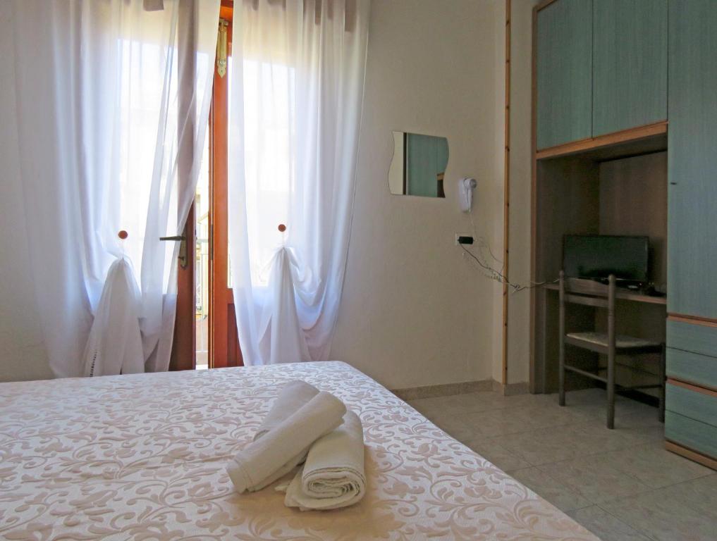 Postel nebo postele na pokoji v ubytování Hotel Saturno