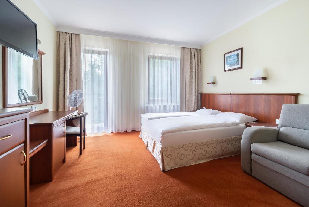 ミコワイキにあるPokoje Fregataのベッドとソファ付きのホテルルーム