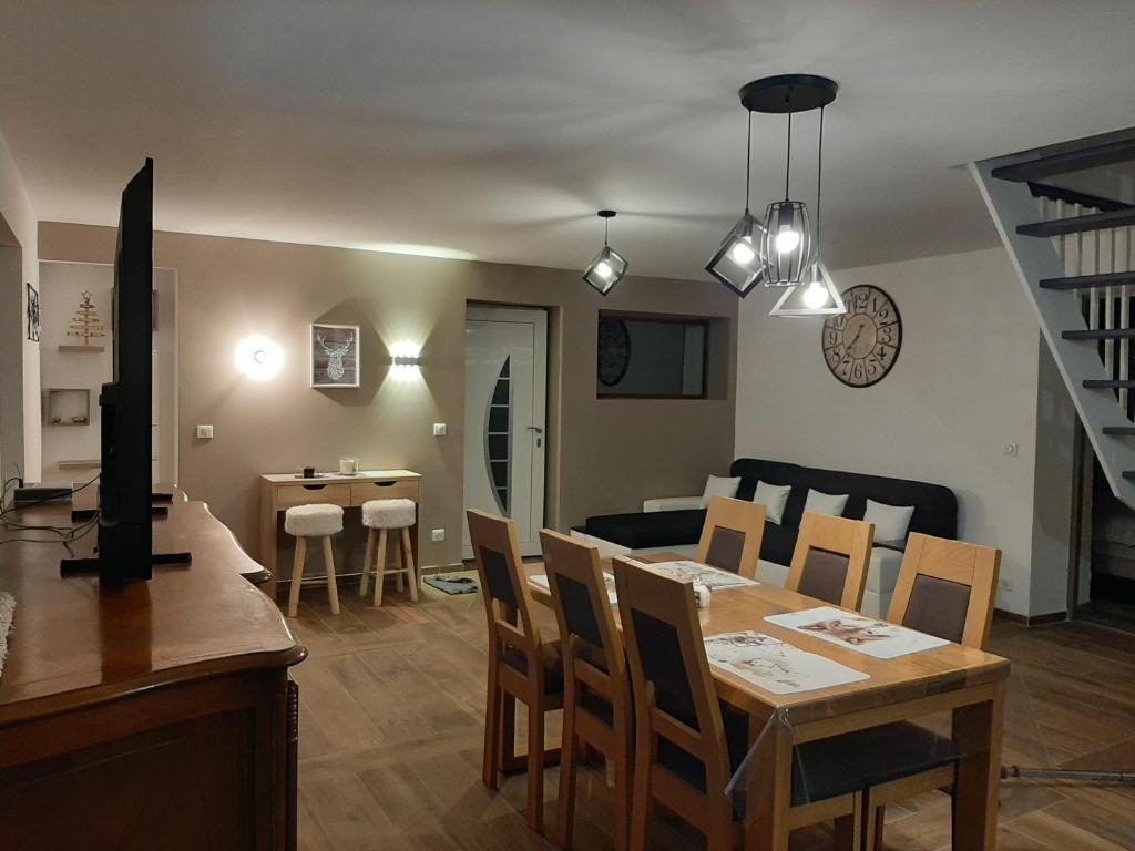 Un comedor y una sala de estar con mesa y sillas. en La Maison Trésallet, en La Plagne Tarentaise