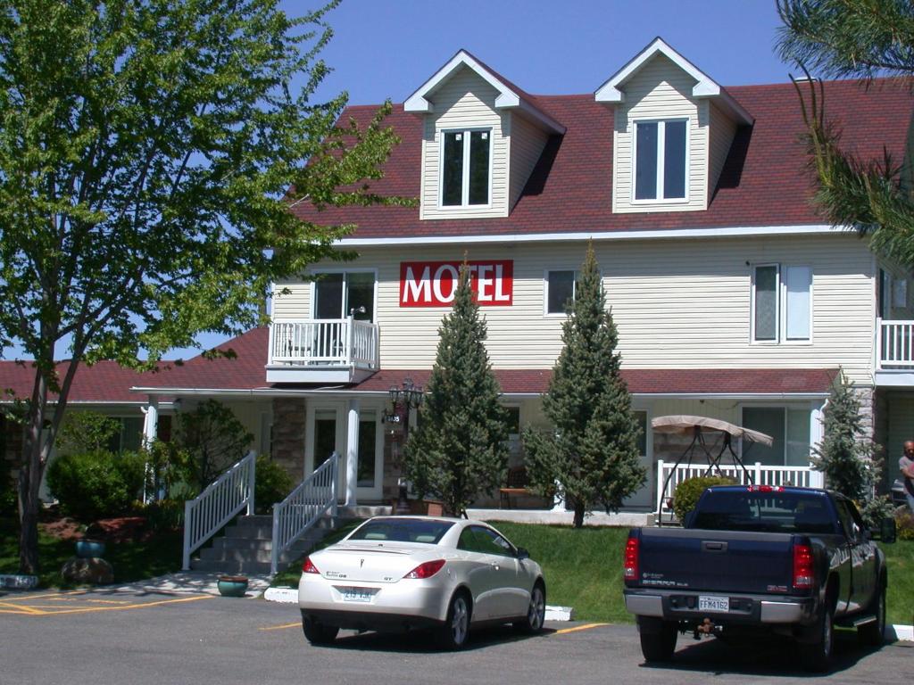 a white car parked in front of a house at Motel Derfal in Repentigny