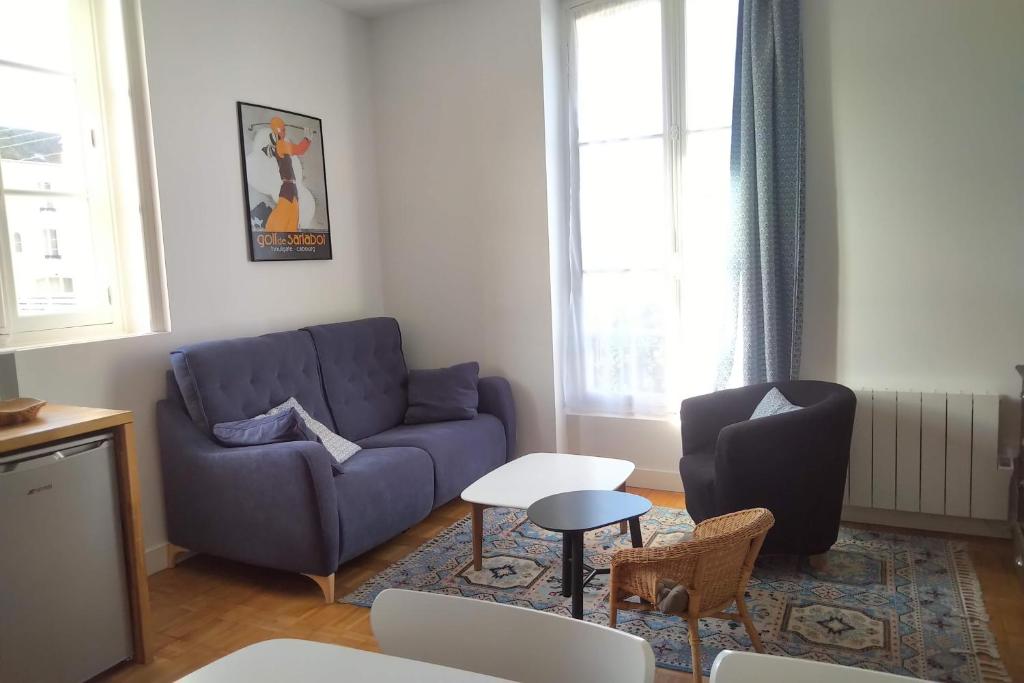 カブールにあるappartement dans villa cabourgeaiseのリビングルーム(青いソファ、テーブル付)