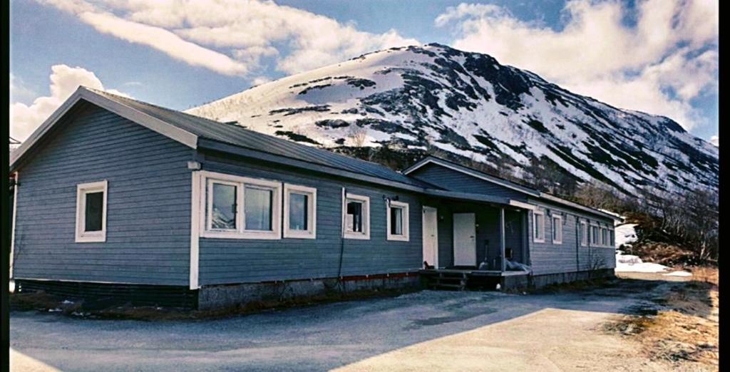 a house in front of a snow covered mountain at MelisHome: Aurora Observatory in Tromsø